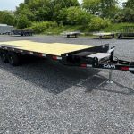 a CAM Superline deckover equipment trailer with slide out ramps