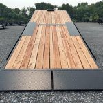 a Bwise wooden deck parked in a gravel lot