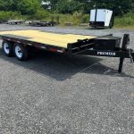 a Premier flatbed trailer parked in a gravel lot
