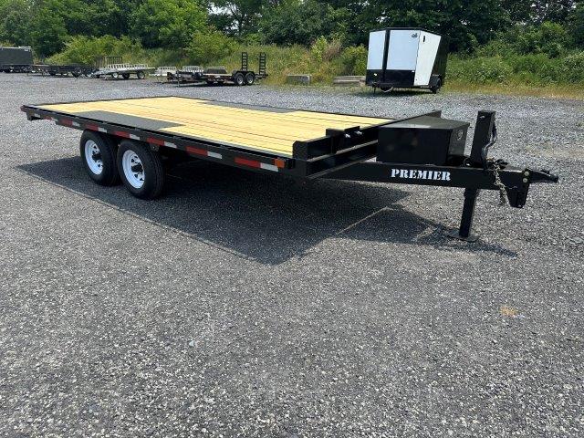 a Premier flatbed trailer parked in a gravel lot
