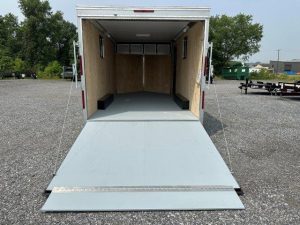 the inside of a trailer with the door open is sitting in a gravel lot