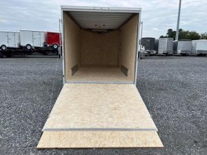 an ATC trailer with the door open parked in a gravel lot