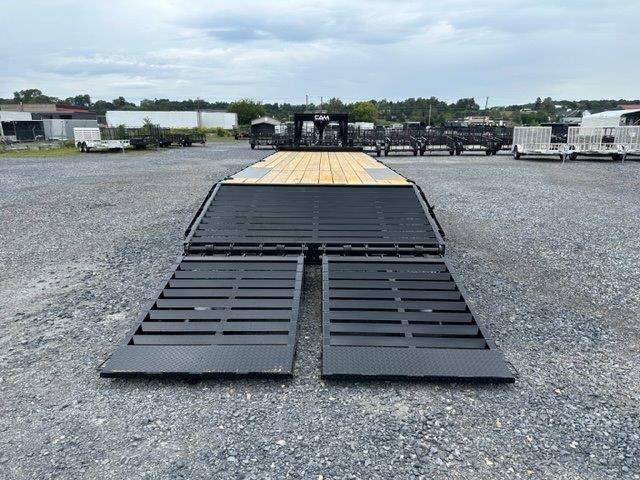 a CAM Superline flatbed trailer parked in a gravel lot