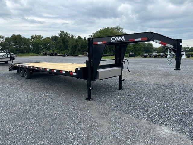 a CAM Superline flatbed trailer parked in a gravel lot
