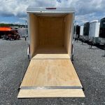 an empty Car Mate trailer parked in a gravel lot