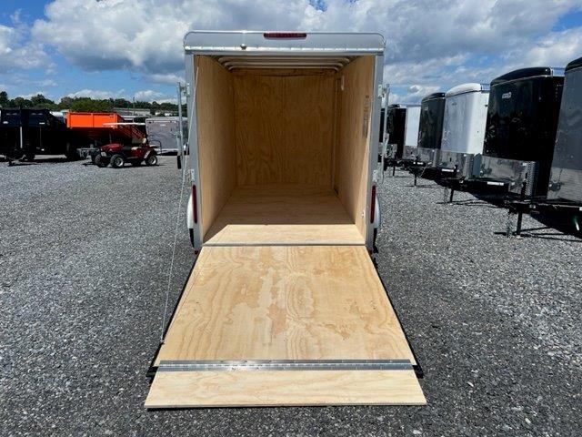 an empty Car Mate trailer parked in a gravel lot