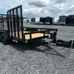 a black trailer parked in a gravel lot