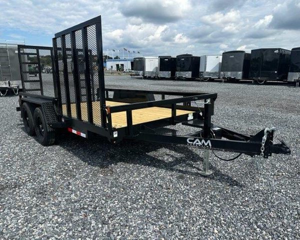 a black trailer parked in a gravel lot