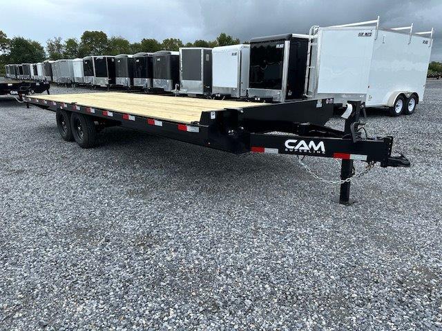 a CAM Superline flatbed trailer parked in a gravel lot