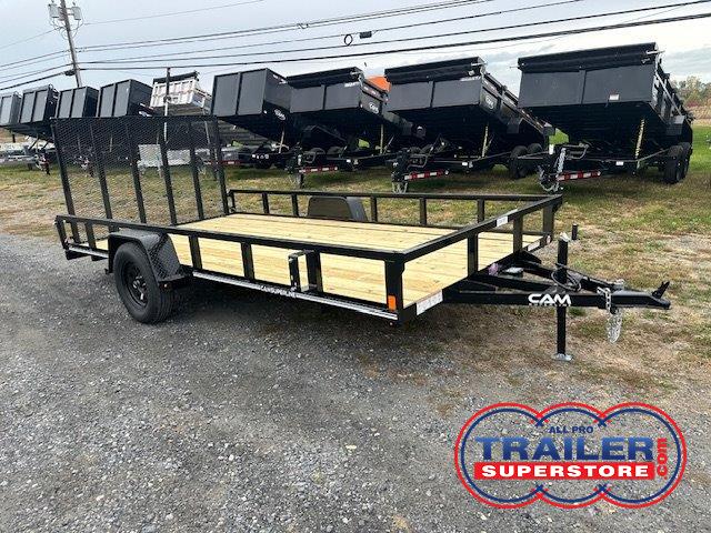 a trailer with a wooden deck is parked in a gravel lot .