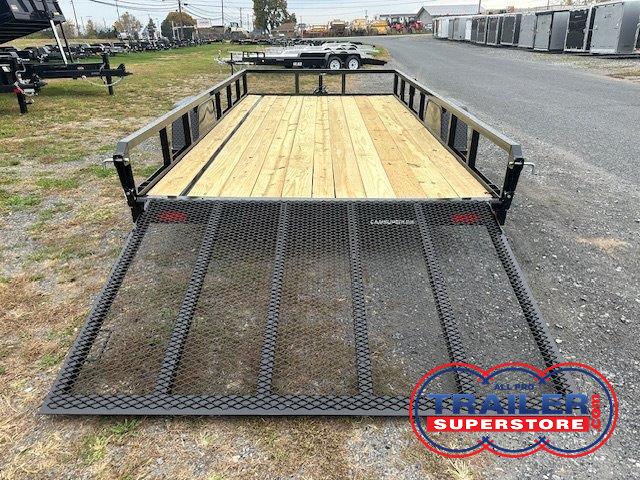 a trailer with a wooden deck and a metal ramp is parked on the side of the road .
