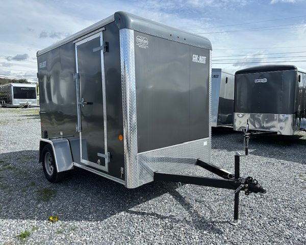 a Car Mate trailer parked in a gravel lot