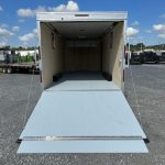 a trailer with the door open is parked in a gravel lot