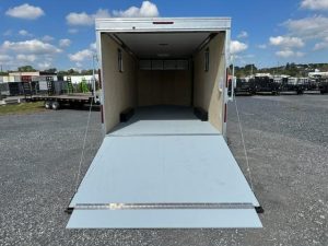 a trailer with the door open is parked in a gravel lot