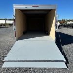 a Car Mate trailer with the door open parked in a gravel lot