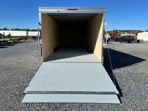 a Car Mate trailer with the door open parked in a gravel lot