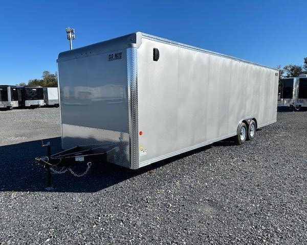 a white trailer is parked in a gravel lot .