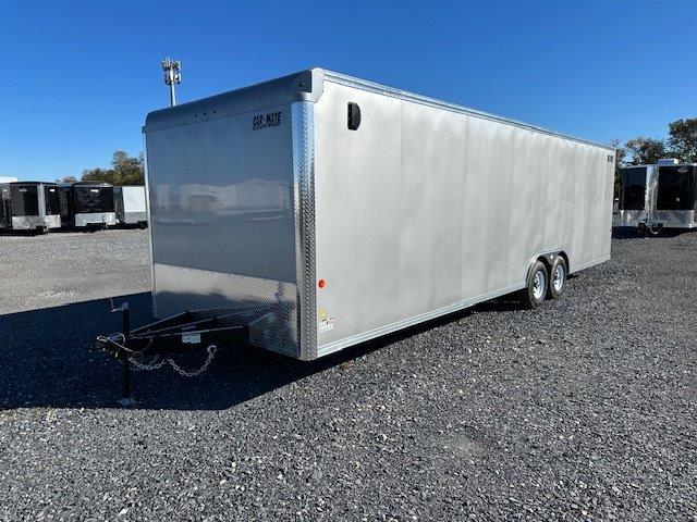 a white trailer is parked in a gravel lot .