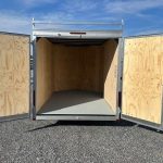 the inside of an empty trailer with the doors open .