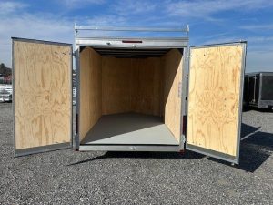 the inside of an empty trailer with the doors open .