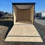 an aluminum enclosed cargo trailer with the ramp door open
