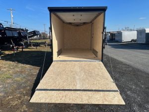 an aluminum enclosed cargo trailer with the ramp door open