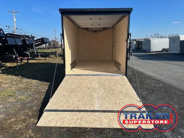 an aluminum enclosed cargo trailer with the ramp door open