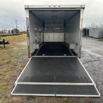 the inside of an aluminum enclosed car trailer is shown with the door open