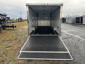 the inside of an aluminum enclosed car trailer is shown with the door open
