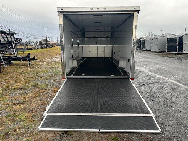 the inside of an aluminum enclosed car trailer is shown with the door open