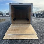 a Homesteader trailer with the door open parked in a gravel lot