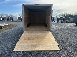 a Homesteader trailer with the door open parked in a gravel lot