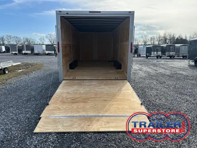 a Homesteader trailer with the door open parked in a gravel lot