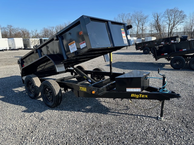 a bigtex dump trailer is parked in a gravel lot