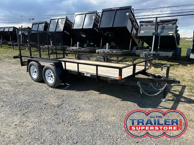 a Car Mate trailer with a wooden deck parked next to a row of dump trailers