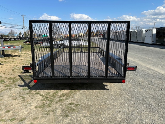 a black trailer with a mesh fence is parked on the side of the road