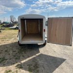 a trailer with its doors open is parked in a parking lot .