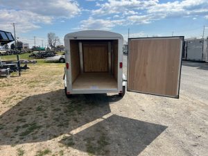 a trailer with its doors open is parked in a parking lot .