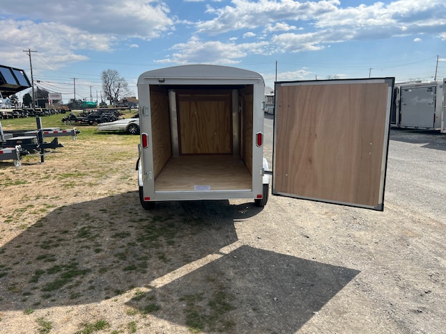 a trailer with its doors open is parked in a parking lot .