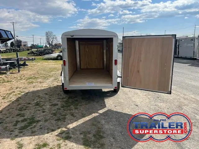 a trailer with its doors open is parked in a parking lot .