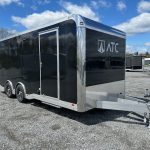 a black atc trailer parked in a gravel lot