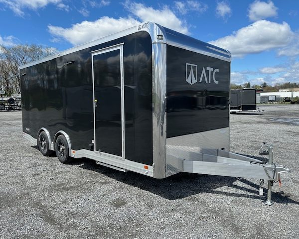 a black atc trailer parked in a gravel lot