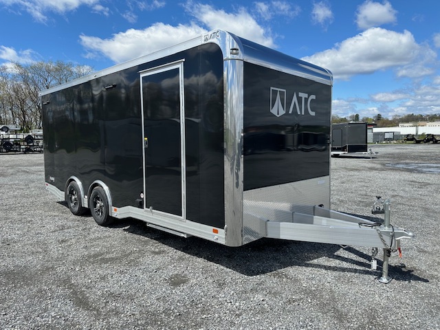 a black atc trailer parked in a gravel lot