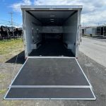 an atc trailer with the door open is parked on the side of the road .
