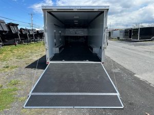 an atc trailer with the door open is parked on the side of the road .