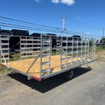 an Alcom trailer with a wooden deck parked on the side of the road