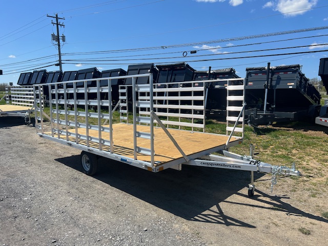 an Alcom trailer parked next to a row of dump trailers