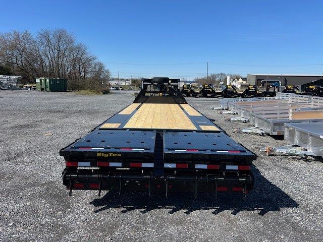 a flatbed trailer is parked in a gravel lot .