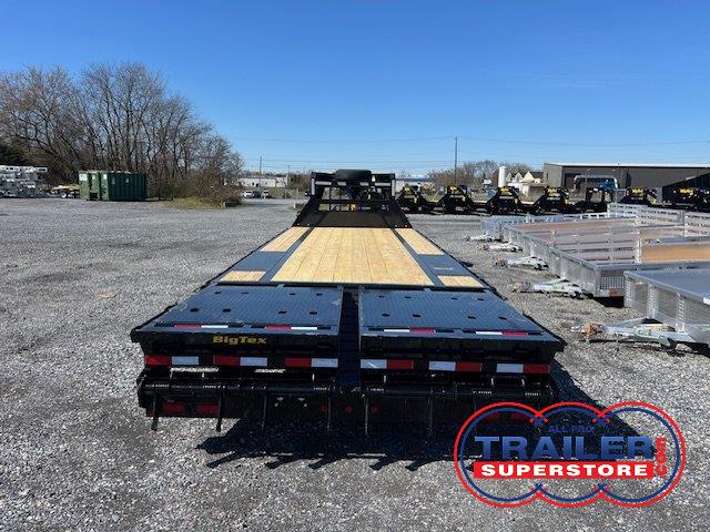 a flatbed trailer is parked in a gravel lot .