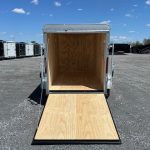 a Car Mate trailer with the door open parked in a gravel lot